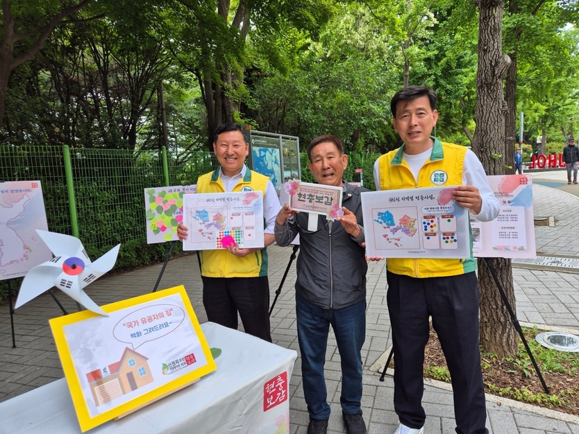 20일 주안지부가 미추홀구 수봉공원에서 현충보감 행사에 서 판넬을 들고 봉사자와 사진을 찍는 시민. ⓒ 신천지자원봉사단 주안지부