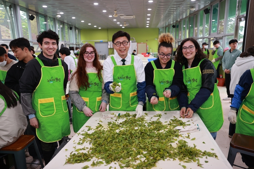 김철우 군수와 보성다향대축제를 방문한 외국인들이 함께 차를 덖고 있다ⓒ보성군청 제공