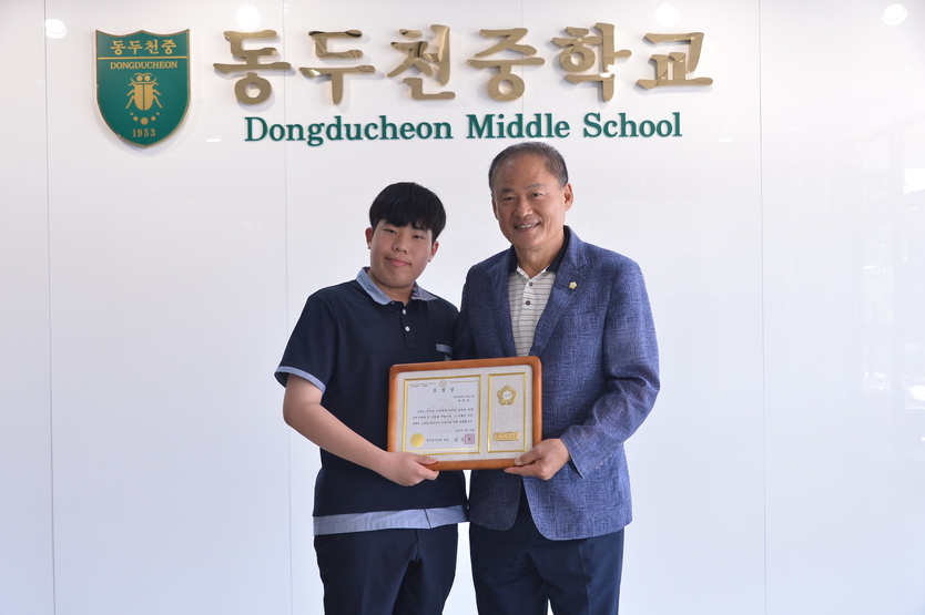 김승호 동두천시의장이 폭염 속 따뜻한 나눔을 한 동두천중학생, 옥현일 학생에게 표창 후 기념촬영을 하고 있다. ⓒ 동두천시의회 제공 