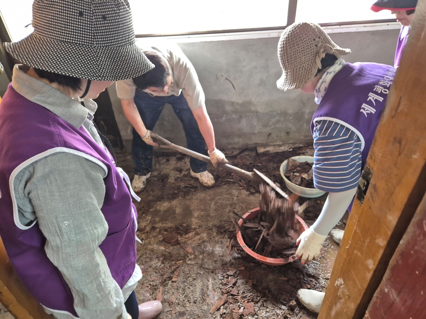 세계평화여성연합 회원들이 침수 피해지역 가옥안의 진흙과 토사를 제거하고 있다 ⓒ 세계평화여성연합 제공
