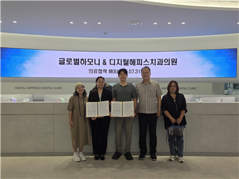 이청희 총괄본부장과 다문화이주여성단 관계자들이 업무협약 체결 후 기념촬영을 하고 있다. ⓒ 해피스치과 제공