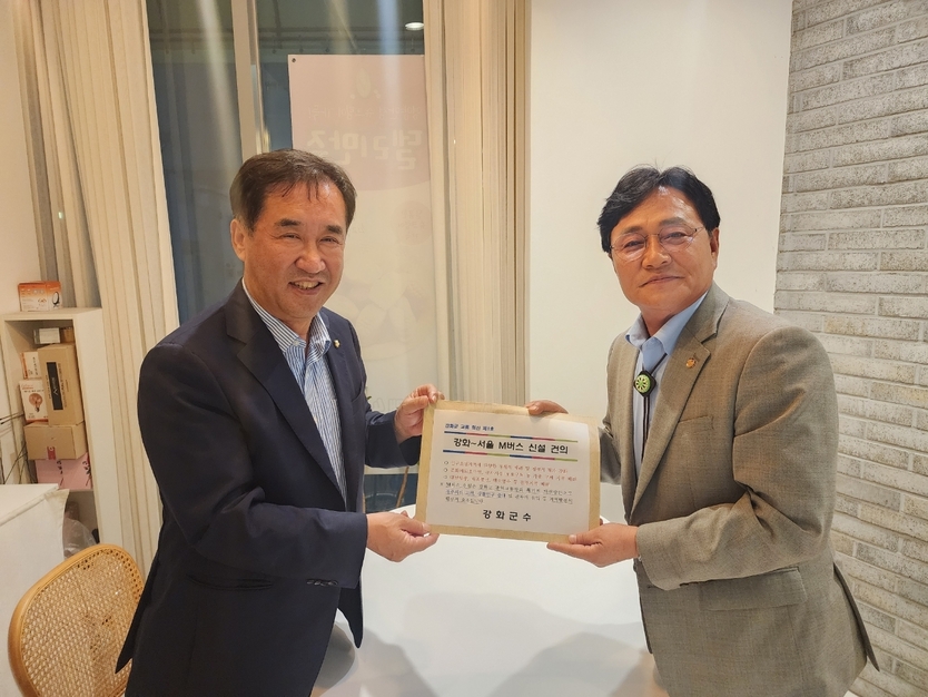 박용철 강화군수가, 맹성규 국토교통위원장에게 M버스 노선 신설 국회에 공식 건의서를 전달하고 있다. ⓒ 강화군 제공