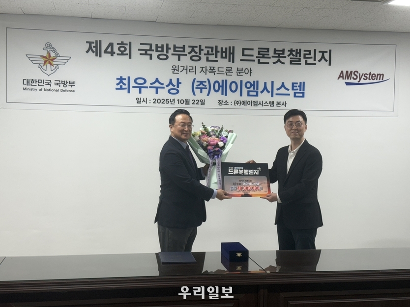 김영익 대표(사진 왼쪽)가 국방부 관계자로부터 축하와 함께 상금을 전달받고 있다. 