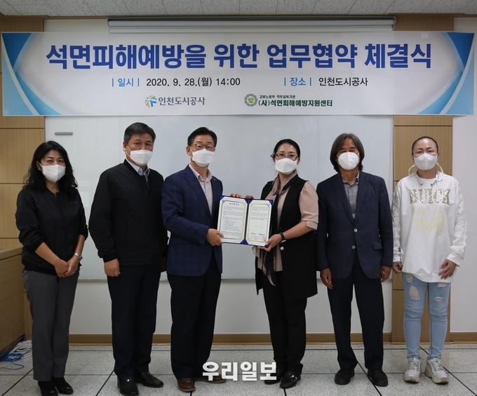 지난달 28일 인천도시공사 김근수 주거복지본부장과 (사)석면피해예방지원센터 최미경 이사장이 공사 본사에서 석면피해예방을 위한 업무협약을 체결하고 있는 모습 ⓒ인천도시공사