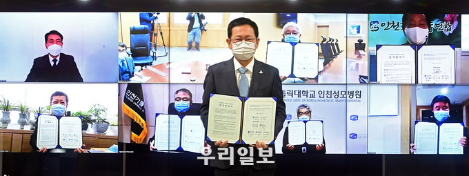 박남춘 인천시장이 접견실에서 열린 '1회용품 없는 장례문화 조성을 위한 비대면 업무협약식'에서 서명한 협약서를 들고 기념촬영을 하고 있다. (첫줄 왼쪽부터 정낙식 자원순환과장, 박남춘 인천광역시장, 김영모 인하대병원장, 심형진 인천환경운동연합대표, 두번째줄 왼쪽부터 조승연 인천의료원장, 김현수 가톨릭관동대학교 국제성모병원장, 홍승모 가톨릭대학교 인천성모병원장, 김양우 가천대길병원장) ⓒ 인천시 제공