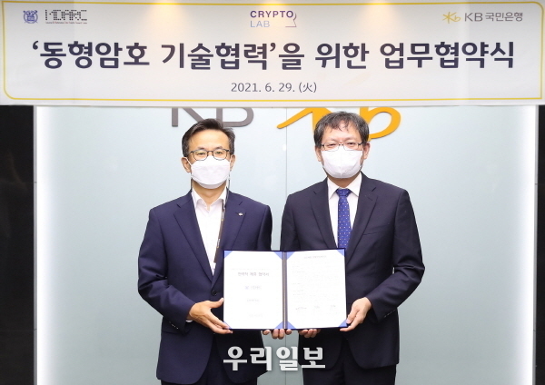 지난 29일 KB국민은행 여의도 신관에서 열린 '동형암호 기술협력'을 위한 업무협약식에서 (왼쪽) 윤진수 KB국민은행 테크그룹 대표와, (오른쪽) 천정희 서울대학교 산업수학센터장 겸 크립토랩 대표가 업무협약을 체결하고 기념촬영을 하고 있다.