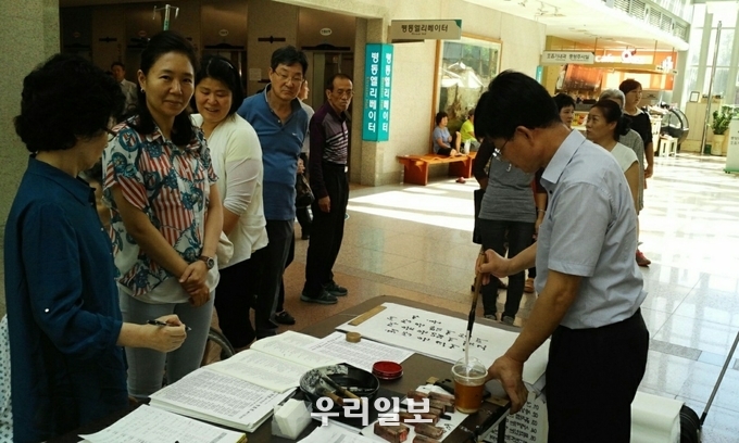 희망의 가훈을 써 주고 있는 현곡(玄谷) 신명섭 서예가