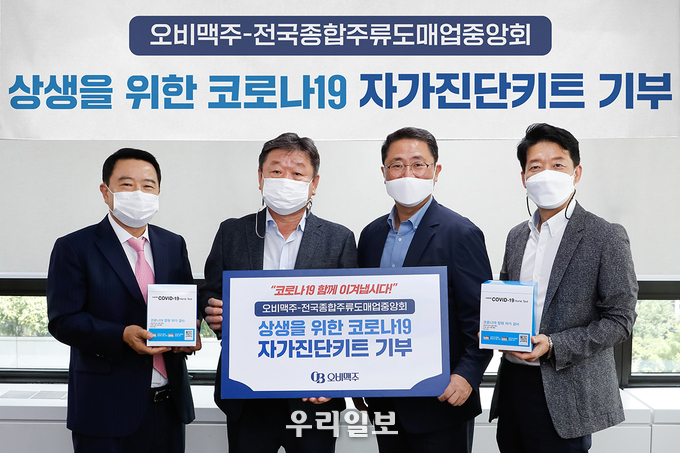(사진 왼쪽부터) 서울주류도매업협회 유준용 회장, 전국종합주류도매업중앙회 이석홍 회장, 오비맥주 최상범 부사장, 오비맥주 김병훈 전무가 전달식 이후 기념 촬영을 하고 있다. ⓒ 오비맥주 제공