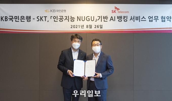 26일 서울 중구 SKT 본사에서 진행된 'KB국민은행-SKT 인공지능 누구 기반 AI뱅킹 서비스 업무 협약식'에서 성채현 KB국민은행 개인고객그룹 대표(왼쪽)와 유영상 SK텔레콤 MNO사업대표(오른쪽)가 기념촬영을 하고 있다.