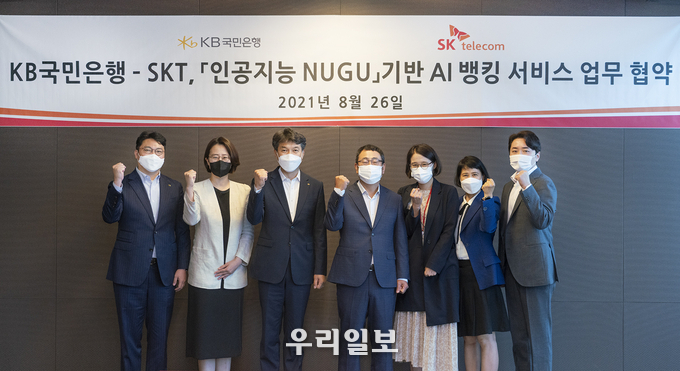 26일 서울 중구 SKT 본사에서 진행된 'KB국민은행-SKT 인공지능 누구 기반 AI뱅킹 서비스 업무 협약식'에서 성채현 KB국민은행 개인고객그룹 대표(왼쪽 세번째)와 유영상 SK텔레콤 MNO사업대표(오른쪽 네번째)가 기념촬영을 하고 있다.