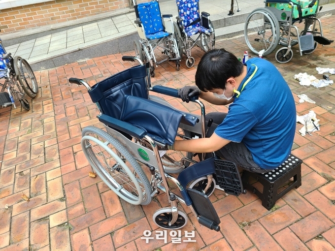 경기도보조기기북부센터 소속 세척요원이 휠체어를 세척-소독하고 있는 모습 