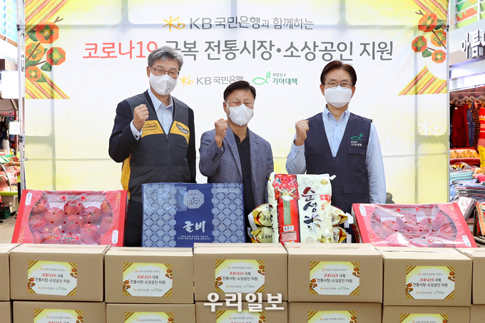 15일 영등포시장에서 열린 코로나19 극복 전통시장ᆞ소상공인 지원 행사에서 (왼쪽부터) 허인 KB국민은행장, 김태원 영등포전통시장 상인회장, 유원식 희망친구 기아대책 회장이 기념촬영을 하고 있다.