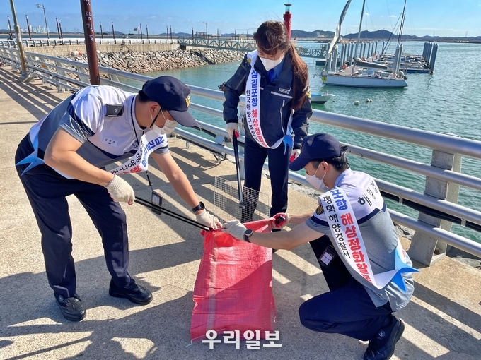 평택해양경찰서 대산구조거점파출소 직원들이 2021년 10월 13일 오전 충남 서산시 삼길포항 주변에서 해양 쓰레기를 수거하고 있다ⓒ 평택경찰서 제공