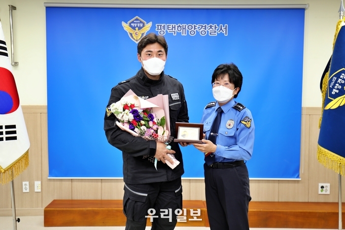 박경순 평택해양경찰서장(오른쪽)이 자랑스러운 평택해경인으로 선정된 김도현 순경에게 공로패를 수여하고, 기념사진을 찍고 있다 ⓒ 평택해양경찰서 제공