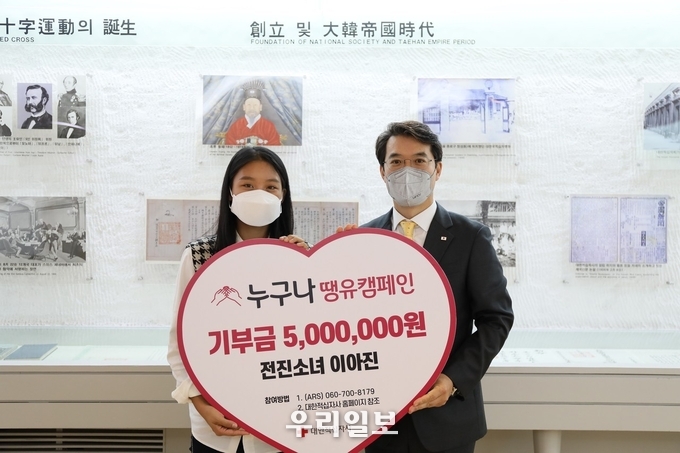  22일(금) 오전 11시 서울 중구 대한적십자사 서울사무소에서 열린 기부금 전달식에서 전진소녀 이아진(사진 왼쪽)과 이재승 대한적십자사 모금전략본부장(사진 오른쪽)이 기념 촬영을 하고 있다.