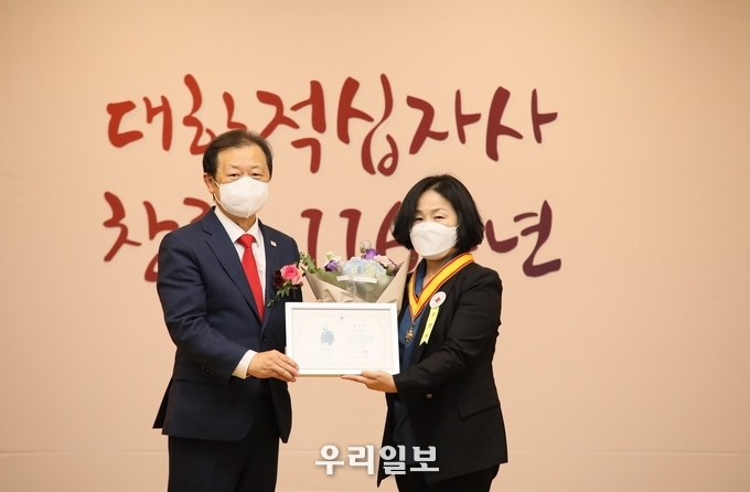 대한적십자사 신희영 회장이 10월 27일(수) 오후 2시, 서울 중구 본사 서울사무소 4층 앙리뒤낭홀에서 개최된 ‘대한적십자사 창립 116주년 기념식’에서 31년간 해외 의료봉사에 헌신하며 ‘말라위의 나이팅게일’로 불리는 아프리카미래재단 백영심 선교사에게 「적십자 인도장 금장」을 수여했다. 백영심 선교사를 대신해 아프리카미래재단 안숙이 부장에게 전수했다. (왼쪽 적십자 신희영 회장, 오른쪽 아프리카미래재단 안숙이 부장) 