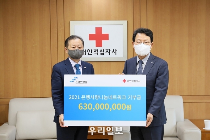 신희영 대한적십자사 회장(왼쪽)이 3일 서울 중구 대한적십자사 서울사무소에서 김광수 은행연합회 회장(오른쪽)으로부터 '은행사랑나눔네트워크' 성금 3억 5천만 원과 2억 8천만 원 상당의 물품을 기부받은 후 기념촬영을 하고 있다. 