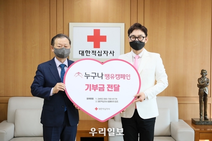 서울 중구 대한적십자사 서울사무소에서 열린 기부금 전달식에서 신희영 대한적십자사 회장(사진 왼쪽)과 가수 추가열(사진 오른쪽)이 기념 촬영을 하고 있다. 