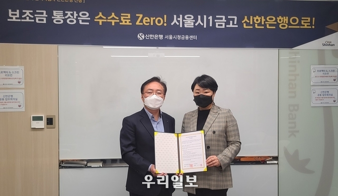 서울시청년활동지원센터와 신한은행이 업무협약을 체결하고 협약서를 펼쳐보이고 있다. 