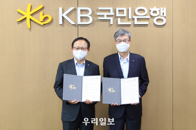 지난 19일 KB국민은행 여의도 신관에서 열린 'ESG 가치 이행 및 RE100 성공적 실행을 위한 업무 협약식'에서 (오른쪽)허인 KB국민은행장과 (왼쪽)정기섭 포스코에너지 사장이 업무협약을 체결하고 기념촬영을 하고 있다.