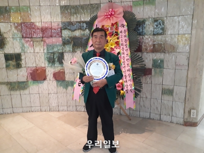 천하종합(주) 호흡기질환연구소 발명가 한기언 대표이사가 2021년 12월 24일 프레스센터 국제회의장에서 제21회 대한민국 인물 대상 선정위원회가 선정한 '코로나19 방역.보건위생 대상' 수상을 받고 상패를 들고 기념촬영을 하고 있다. 