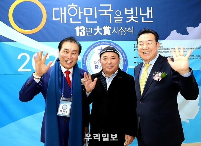 지난 2021년 12월 20일 제4회 대한민국을 빛낸 13인 대상 시상식 개최를 마치고 조직위원회 박희영 총재(왼쪽), 김재덕 준비위원장(가운데), 홍성문 심사위원장(오른쪽)이 손을 들고 기념촬영을 하고 있다.
