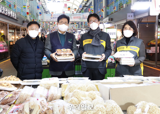19일 영등포 전통시장에서 열린 설날맞이 '전통시장 사랑나눔 행사'에서 (왼쪽부터) 김태원 영등포 전통시장 상인회장, 유원식 희망친구 기아대책 회장, 이재근 KB국민은행장, 문혜숙 KB국민은행 ESG본부 상무가 한과를 구입하고 기념촬영을 하고 있다. 
