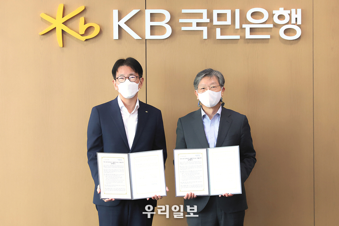 31일 KB국민은행 여의도 신관에서 열린 그린 선도기업 육성 및 수출바우처사업 지원을 위한 업무협약식에서 (왼쪽)이재근 KB국민은행장과 (오른쪽)유정열 KOTRA 사장이 기념촬영을 하고 있다.