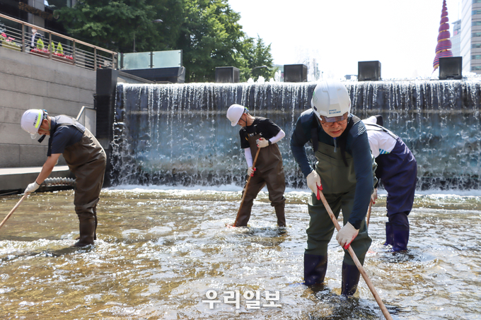 포스코O&M 김정수 대표가 직원들과 청계천 하상 청소를 실시하고 있다 (우측 2번째 김정수 대표) ⓒ 포스코O&M 제공