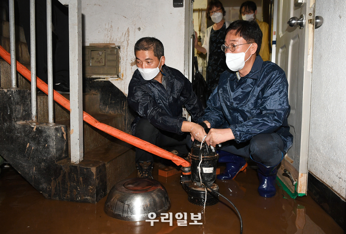 이민근 안산시장(오른쪽)이 반월동장과 함께 침수 주택을 찾아 배수펌프를 작동하고 있다.(사진=안산시청)