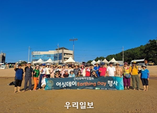 지난 8월 20일 사단법인 국제어싱협회 김필용 이사장과 회원들이 을왕리 해수욕장에서 정기 어싱데이(Earthing Day)행사<br>
기념촬영을 하고 있다.