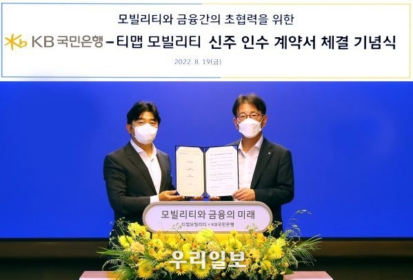 지난 19일 서울시 중구에 위치한 SKT타워에서 열린 KB국민은행-티맵모빌리티 전략적 투자 계약 체결식에서 (왼쪽)이종호 티맵모빌리티 대표와 (오른쪽)이재근 KB국민은행장이 기념촬영을 하고 있다.