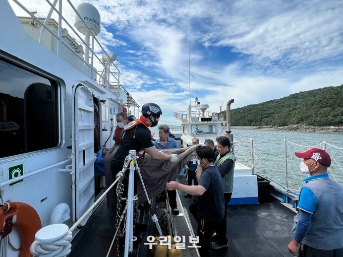 평택해양경찰서 경비함에서 응급환자를 어선에서 인계받고 있다. ⓒ평택해경 제공