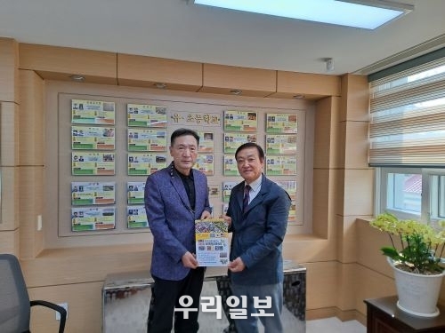 (사)세계밀리터리룩 페스티벌 백호현 이사장(오른쪽)이 연천교육지원청 안선근 교육장(왼쪽)에게 제6회 세계밀리터리룩 페스티벌 포스터를 전달하고 있다.