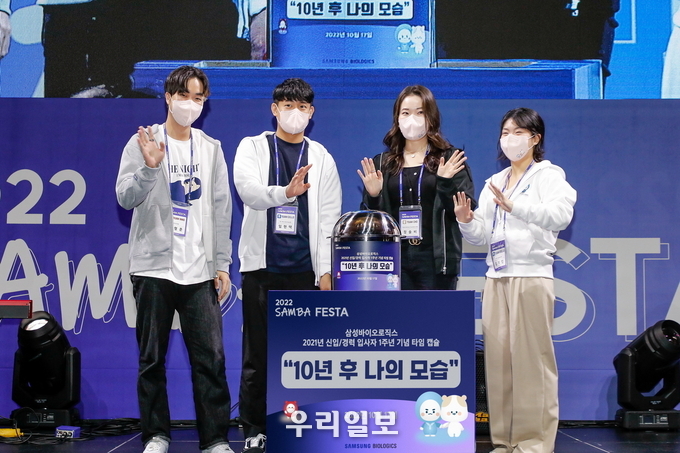 '2022 삼바 축제(SAMBA FESTA)'에서 삼성바이오로직스 신규 입사자들이 각자의 목표와 다짐을 적은 종이를 타임캡슐에 넣고 기념 촬영을 하고 있는 모습. 타임캡슐은 10년 후인 2032년 10월에 개봉될 예정이다 ⓒ 삼성바이오로직스 제공