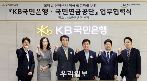 지난 4일 서울시 영등포구 KB국민은행 신관에서 열린 '모바일 전자문서 이용 활성화를 위한 업무협력식'에서 (왼쪽 세번째)성채현 KB국민은행 개인고객그룹 대표, (왼쪽 네번째)김청태 국민연금공단 디지털혁신본부장 및 양 기관 관계자가 기념촬영을 하고 있다.