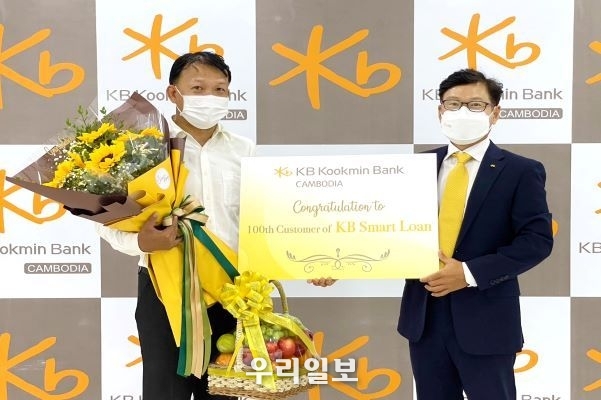 KB캄보디아은행 본점에서 열린 KB스마트론 신규고객 기념 행사에서 (오른쪽)장용재 KB캄보디아은행 법인장과 고객이 기념촬영을 하고 있다. 